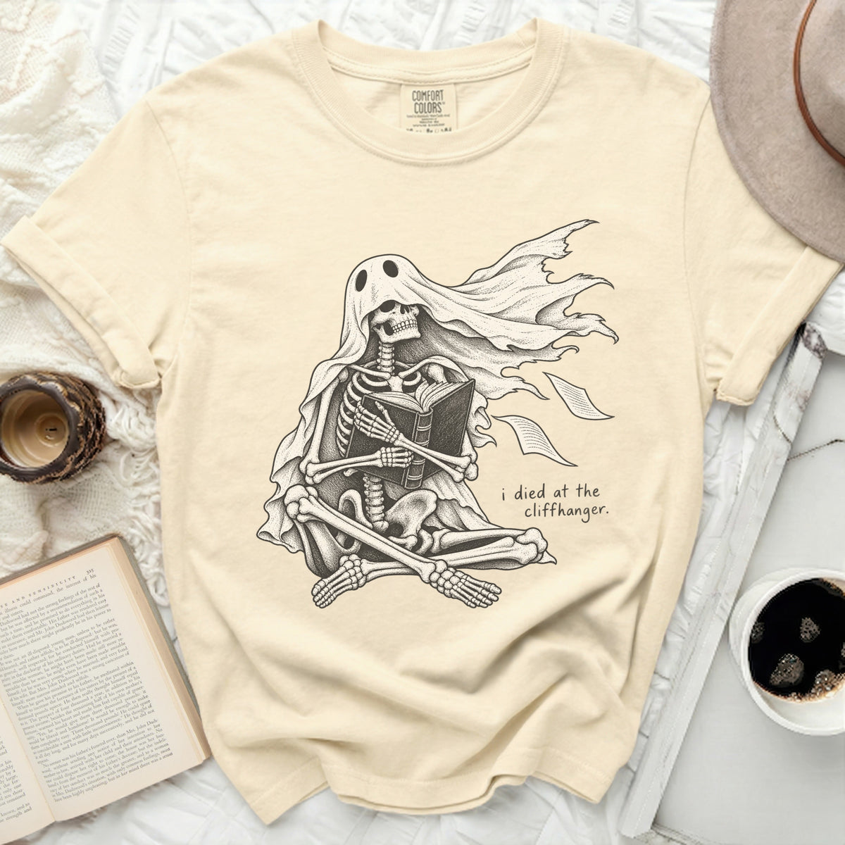 Skeleton ghost reading a book with text "i died at the cliffhanger."