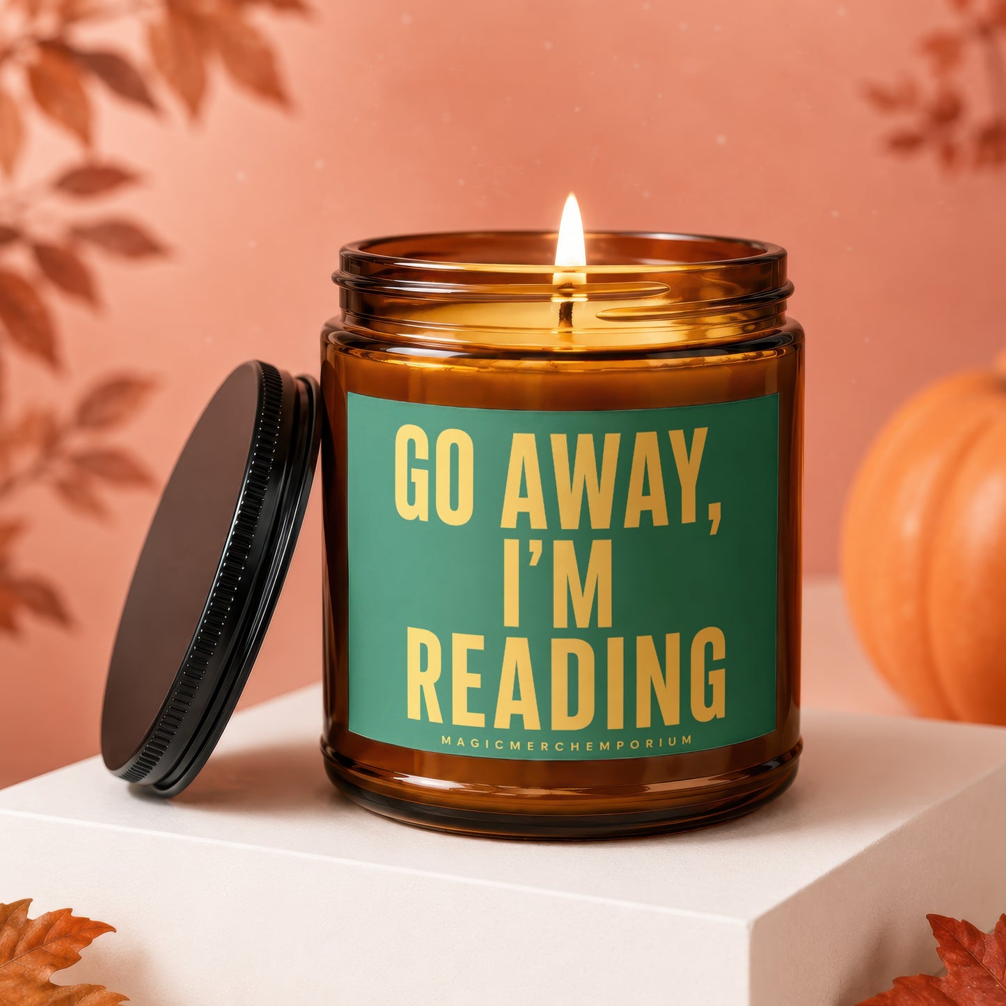 Amber jar candle with lit wick and "Go Away, I'm Reading" text.