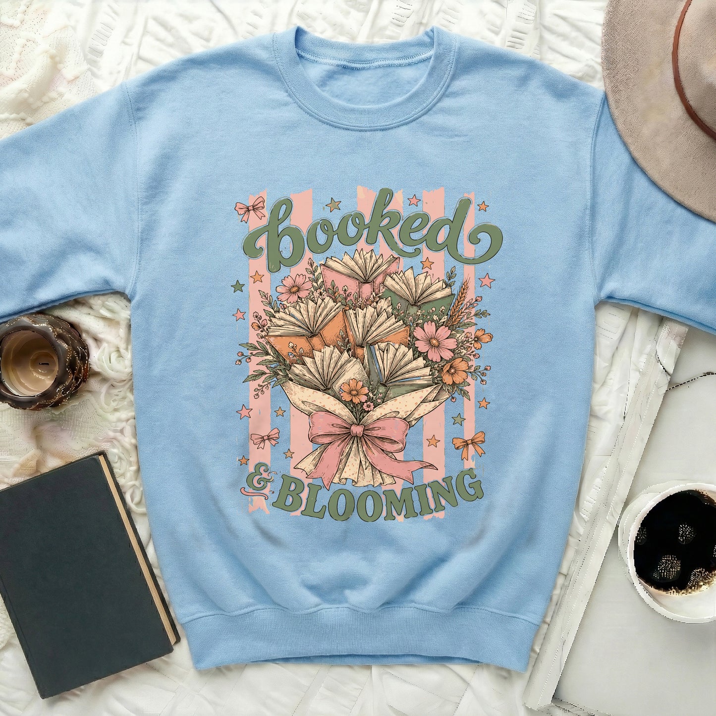 Light blue sweatshirt with "Booked & Blooming" text and book bouquet design.