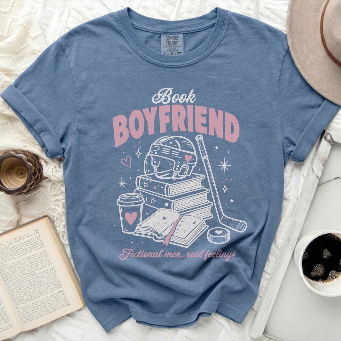 Blue t-shirt with "Book Boyfriend" text, books, hockey gear, and coffee cup.