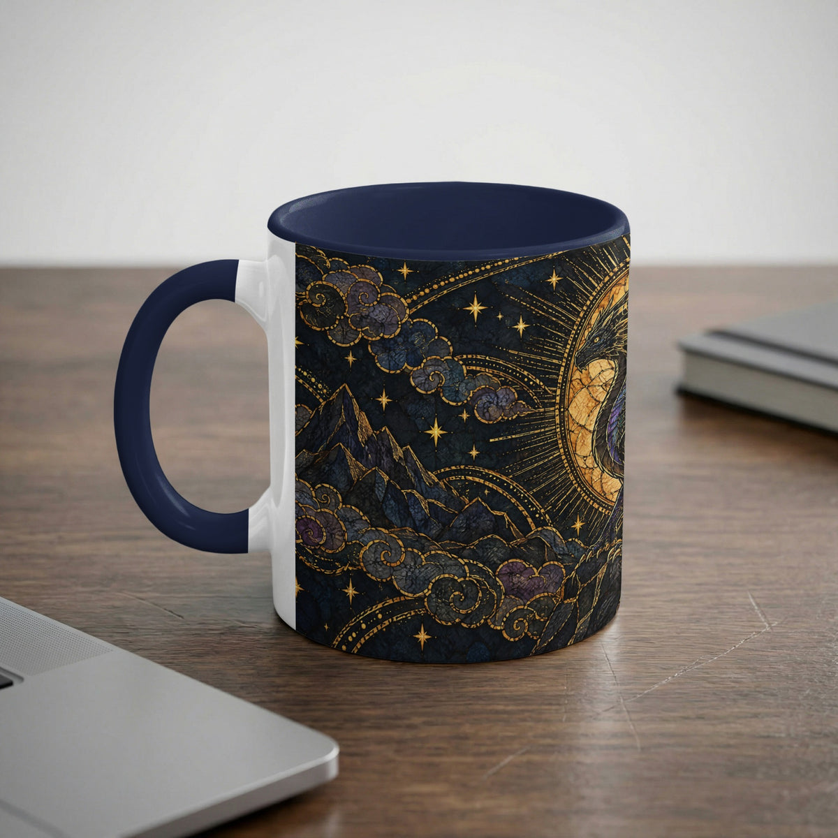A ceramic mug with a dark blue interior and handle featuring a celestial mountain landscape design.