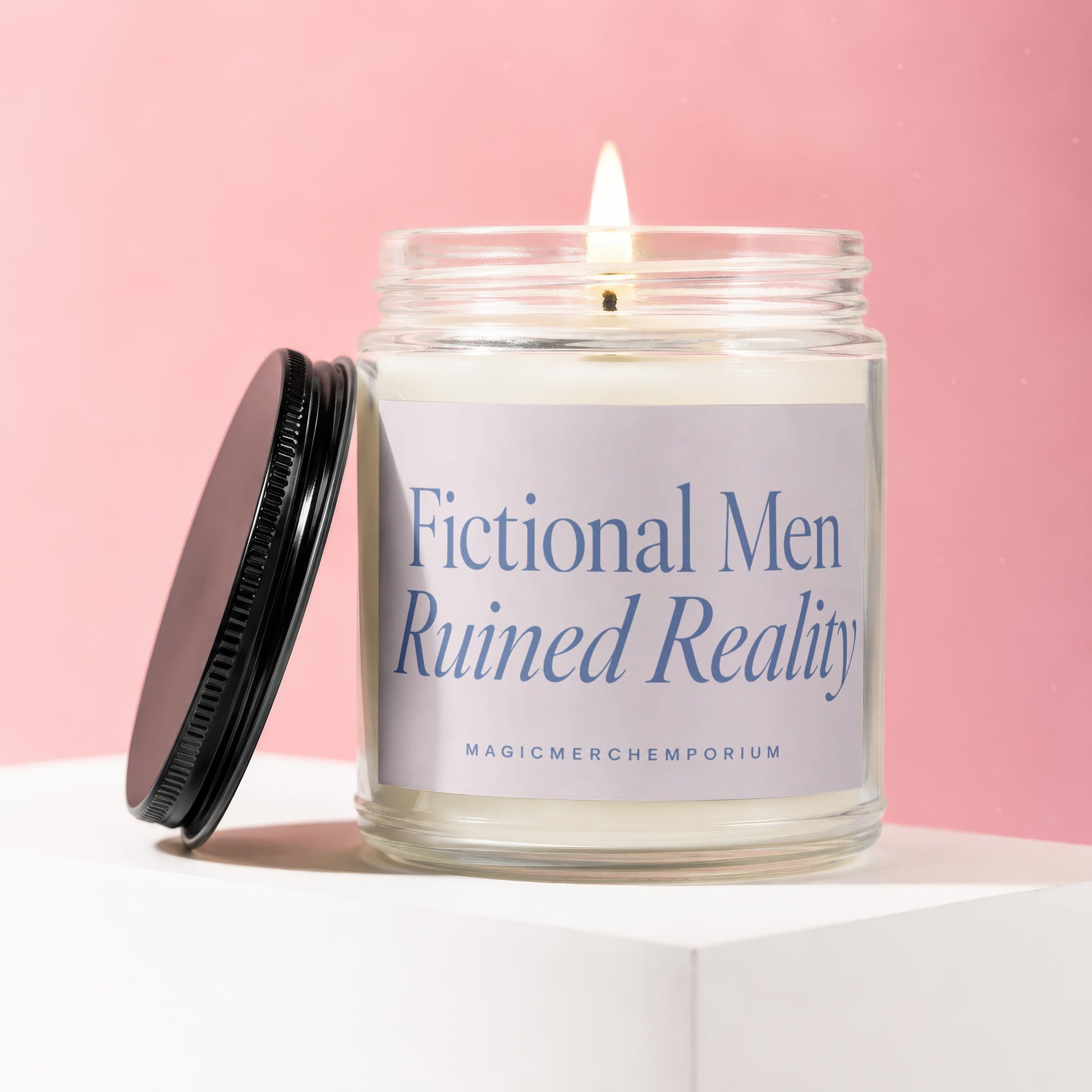 Scented candle in a glass jar with lid off, displaying "Fictional Men Ruined Reality" text.