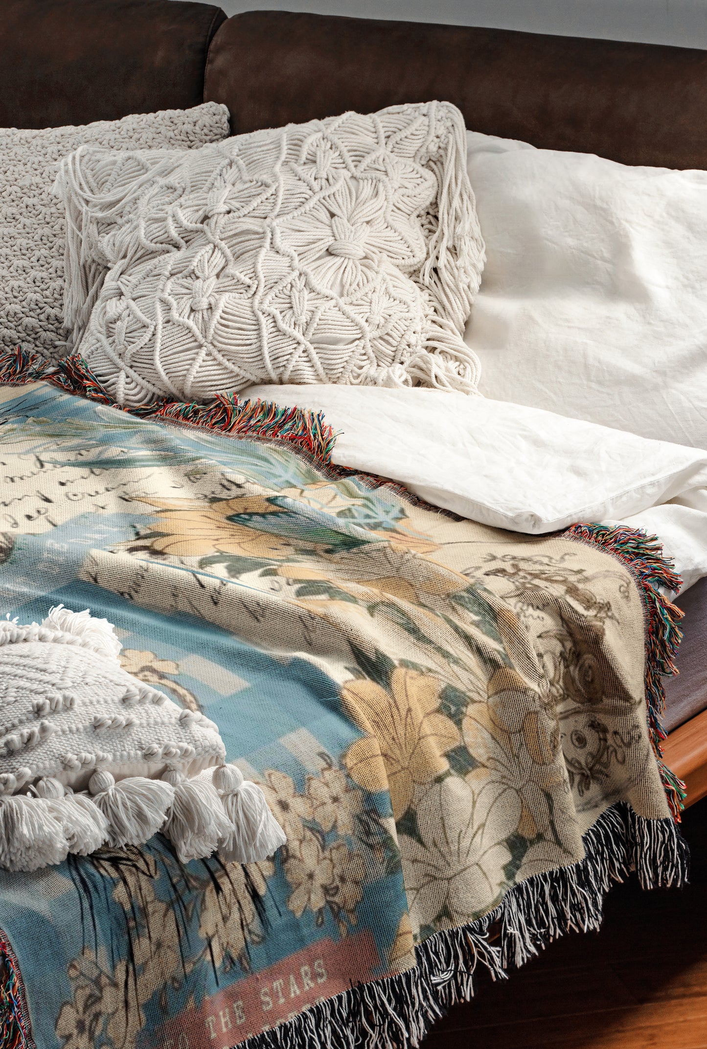 a cozy and inviting bedroom scene, featuring a bed with a colorful blanket and pillows, a wooden headboard, and a brown leather couch.