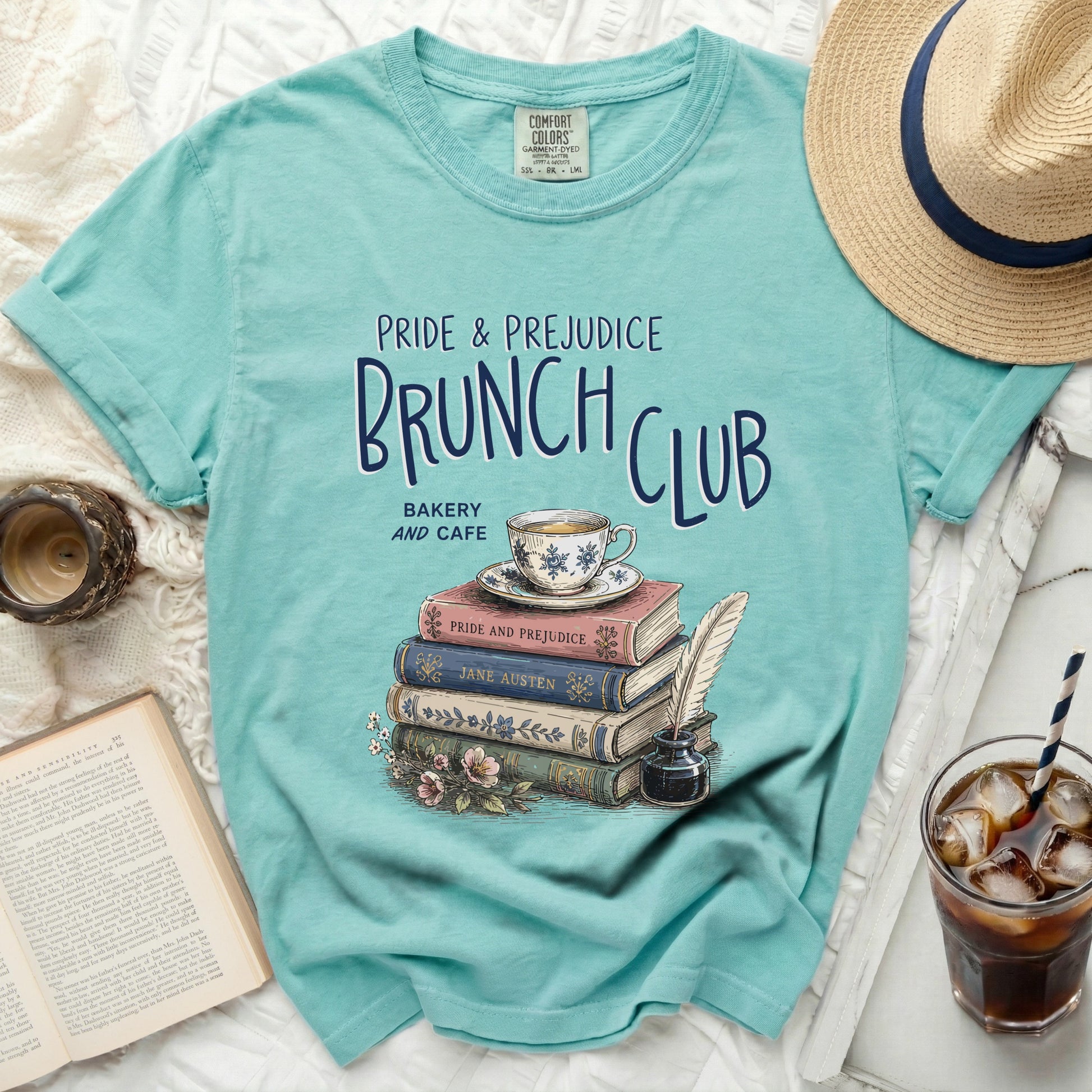 Teal t-shirt with Pride and Prejudice Brunch Club design, stack of books, and teacup.