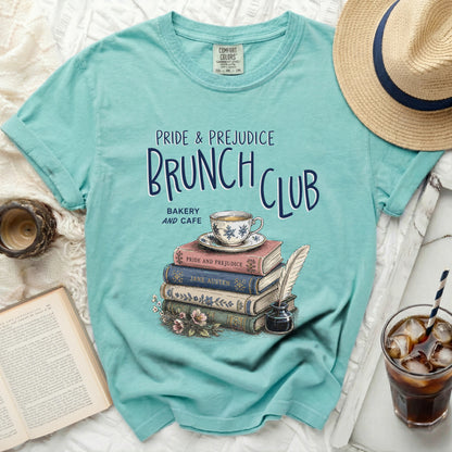 Teal t-shirt with Pride and Prejudice Brunch Club design, stack of books, and teacup.