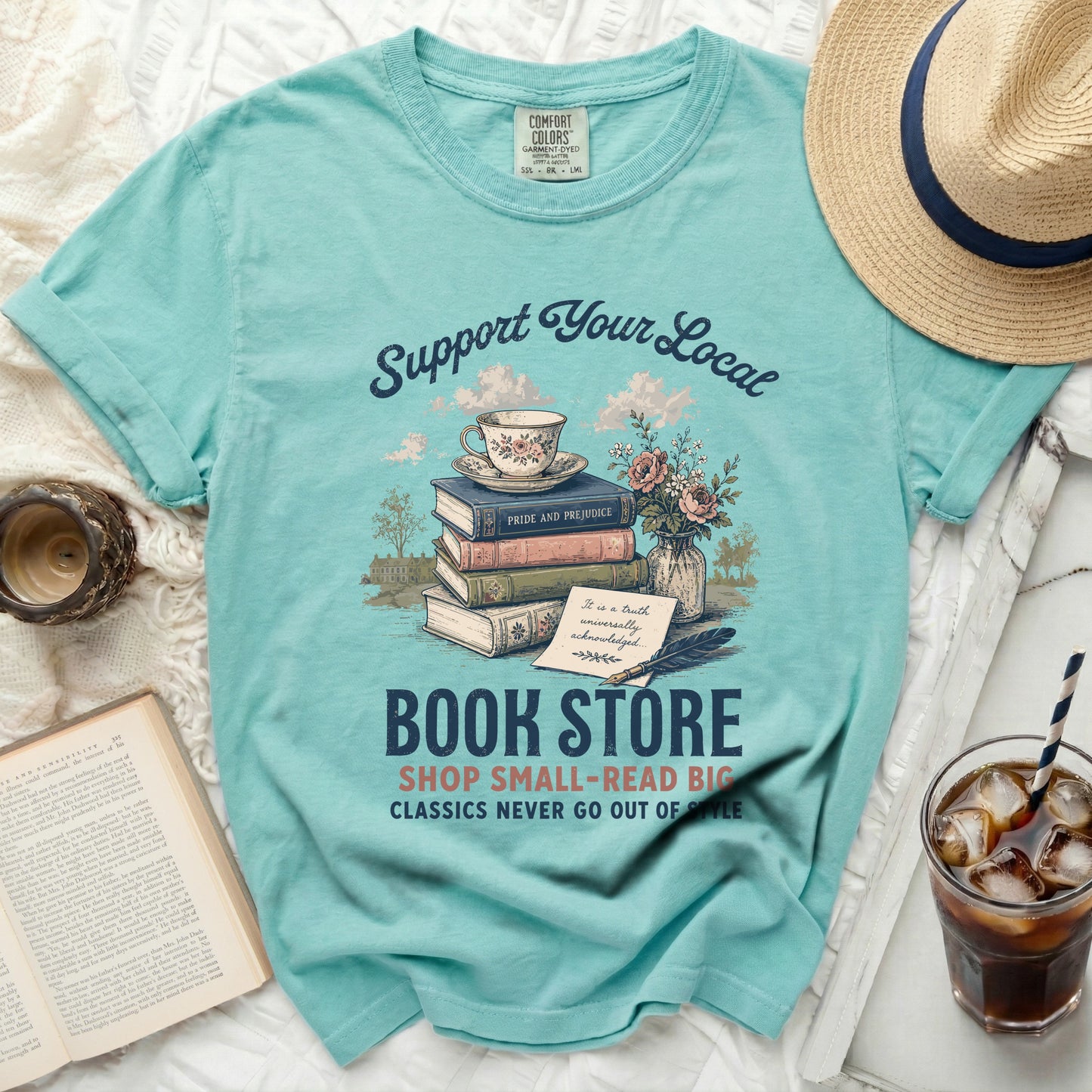 Turquoise t-shirt with "Support Your Local Book Store" graphic and book imagery.