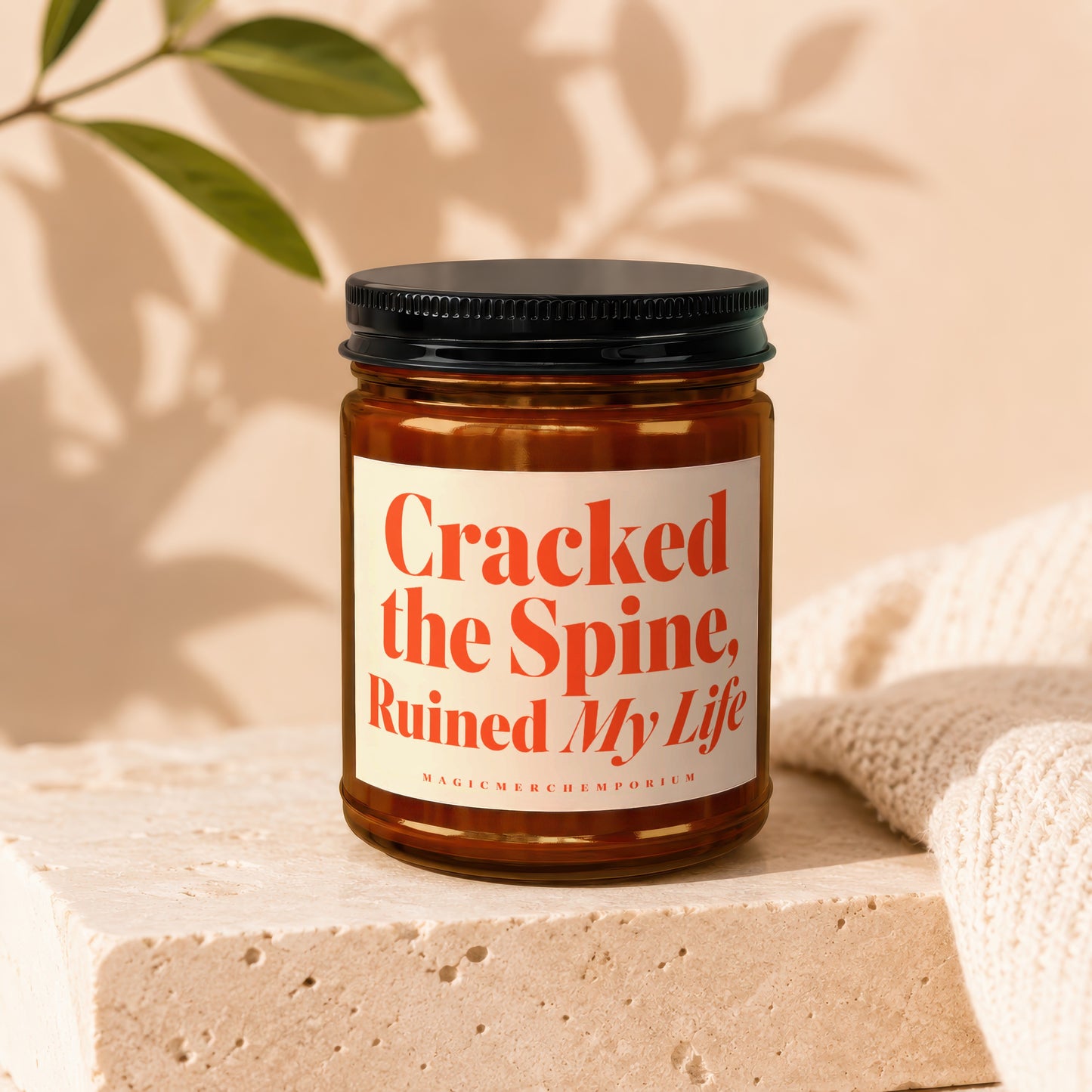 Amber jar candle with label text "Cracked the Spine, Ruined My Life" and "MAGICMERCH ЕMPORIUM".