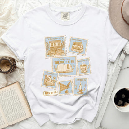 White t-shirt with "The Book Club" graphic featuring vintage postage stamps.