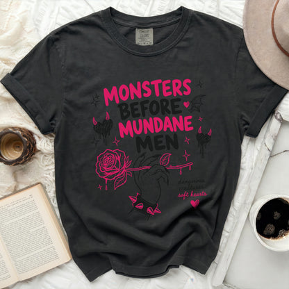 Black t-shirt with pink text "Monsters Before Mundane Men" and rose graphic.