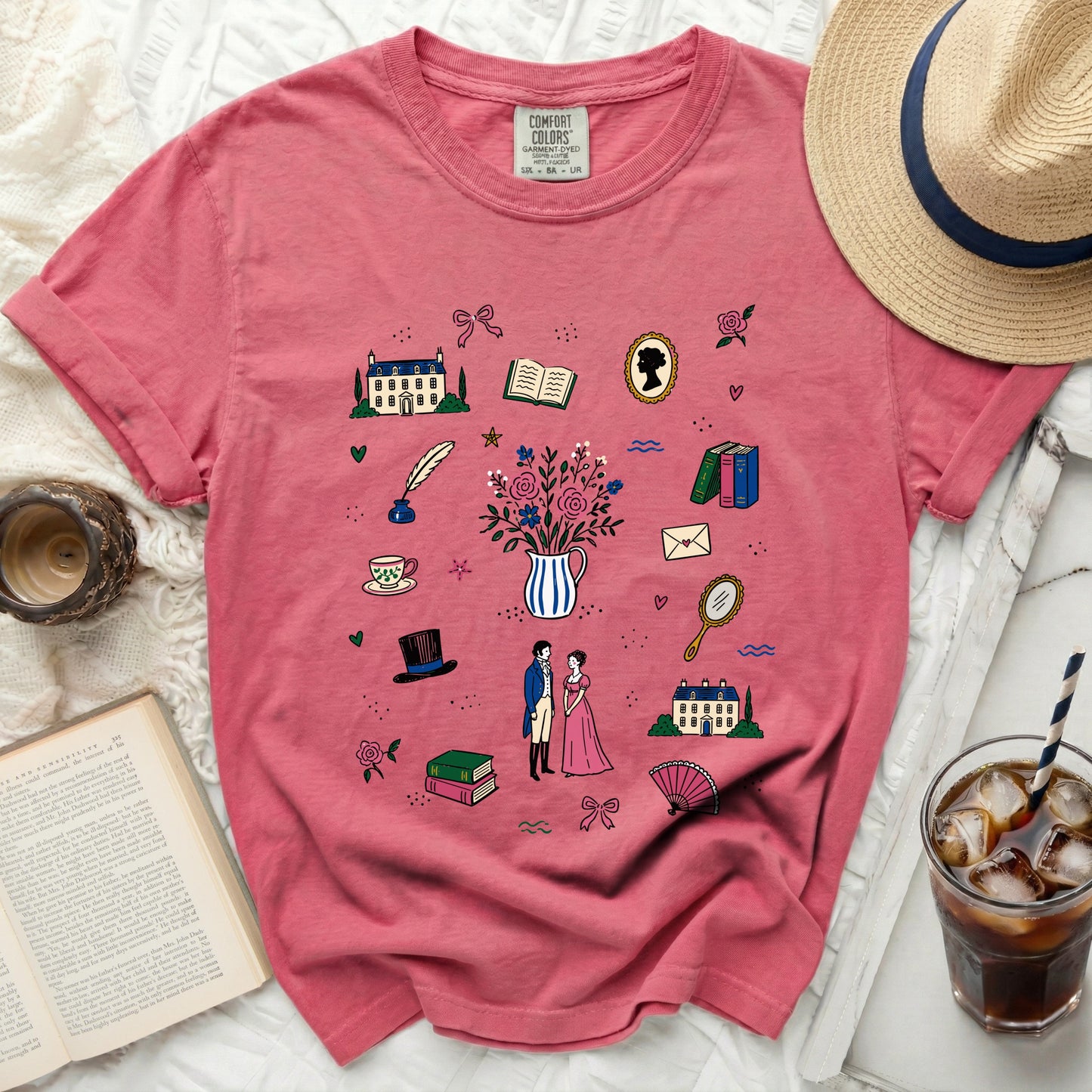 Pink t-shirt with scattered pattern of historical illustrations and a Comfort Colors tag.