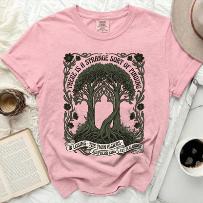 Pink t-shirt with twin trees design and "There is a strange sort of finding" text.