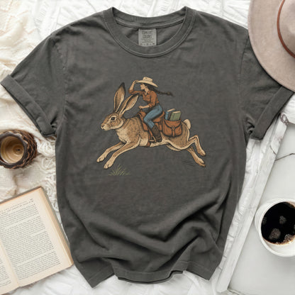 Dark grey t-shirt with a woman riding a rabbit and carrying books.
