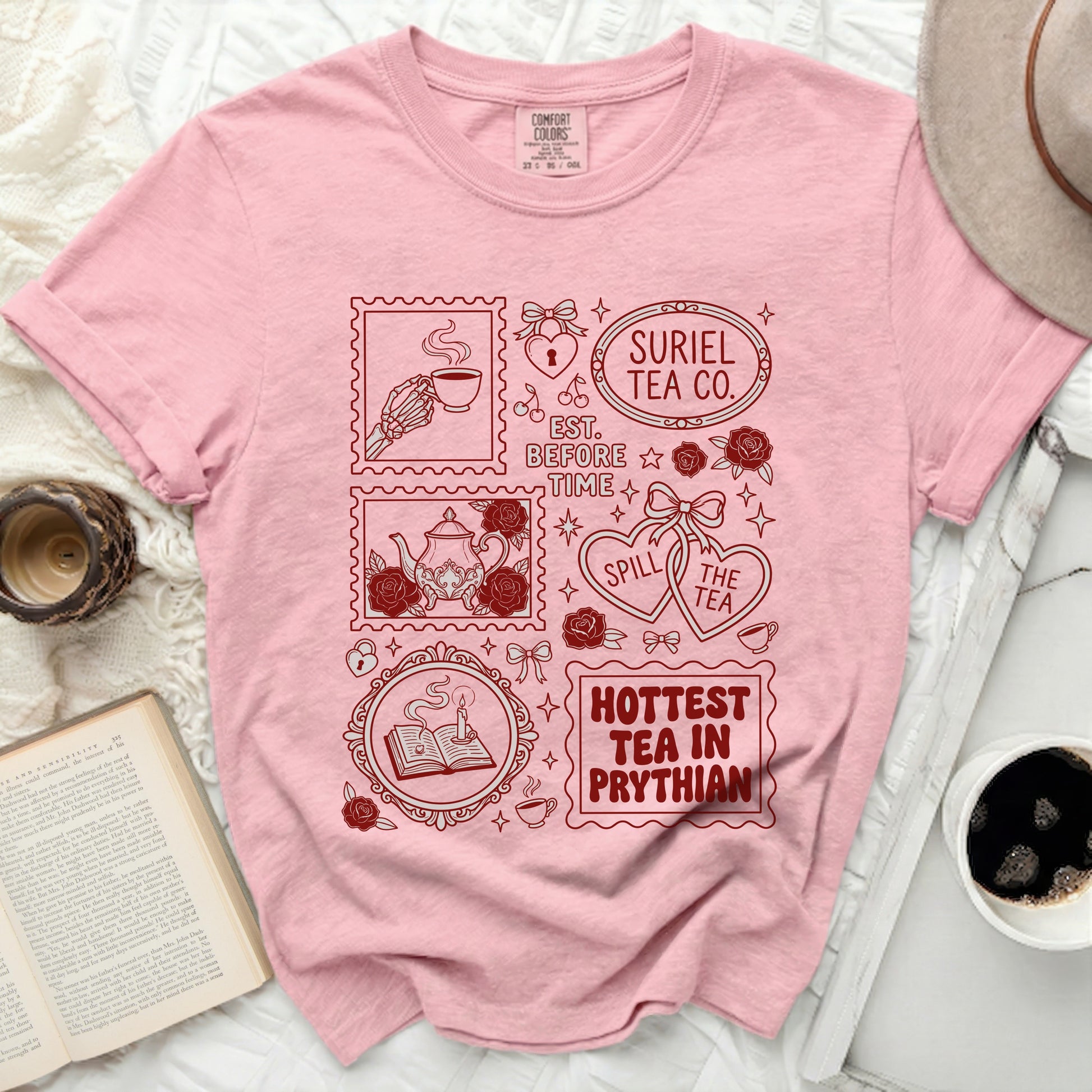 Pink t-shirt with red graphic featuring stamps with tea-related designs and text.