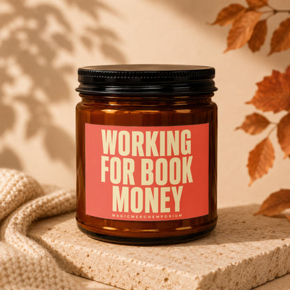 Candle with text "WORKING FOR BOOK MONEY" and "MAGICMERCHUMPORIUM".