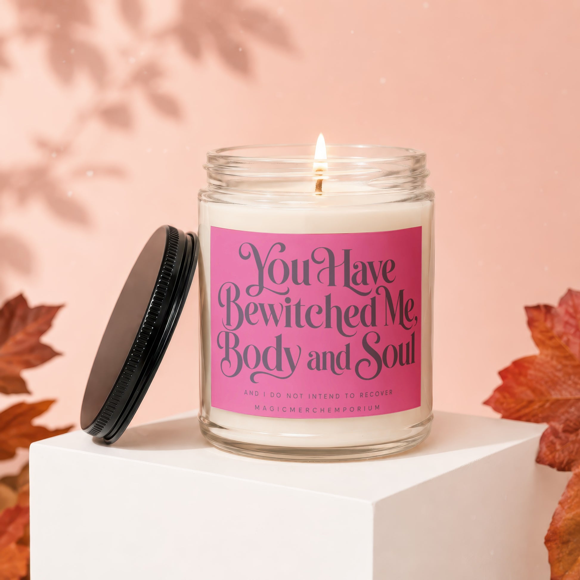 Lit candle with pink label reading "You Have Bewitched Me, Body and Soul."