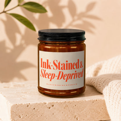 Amber jar candle with label reading "Ink-Stained & Sleep-Deprived MagicMerchEmporium".