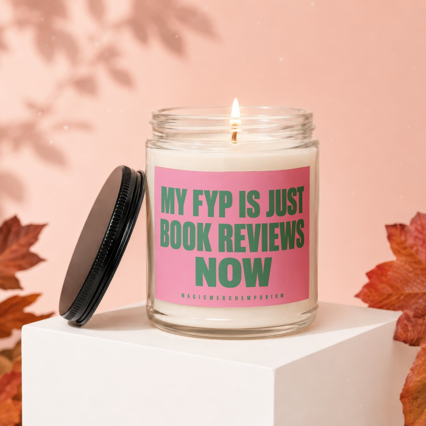 Scented candle with pink label saying "MY FYP IS JUST BOOK REVIEWS NOW".