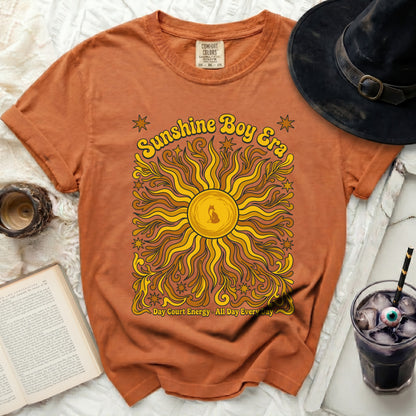 Orange t-shirt with "Sunshine Boy Era" graphic and sun.