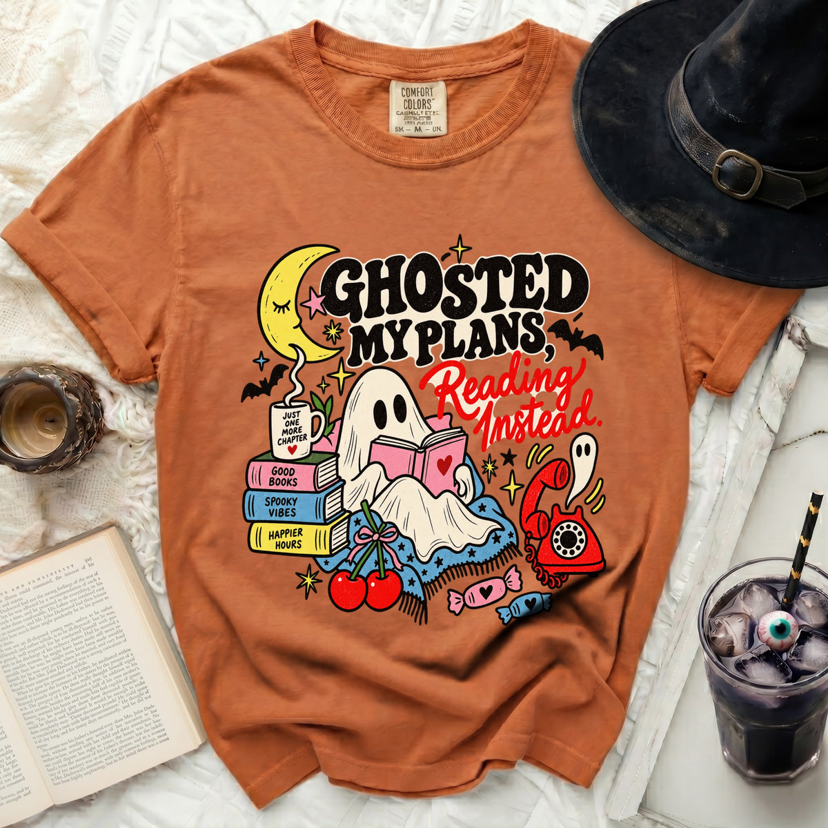 Orange t-shirt with a ghost reading a book and text "Ghosted My Plans, Reading Instead".