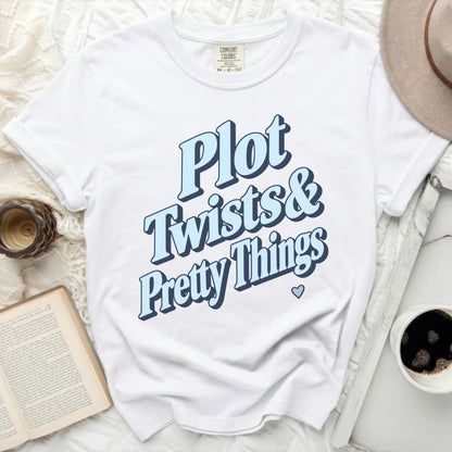 White t-shirt with "Plot Twists & Pretty Things" text in blue font.