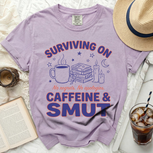 Lavender t-shirt with "Surviving on Caffeine & Smut" graphic.