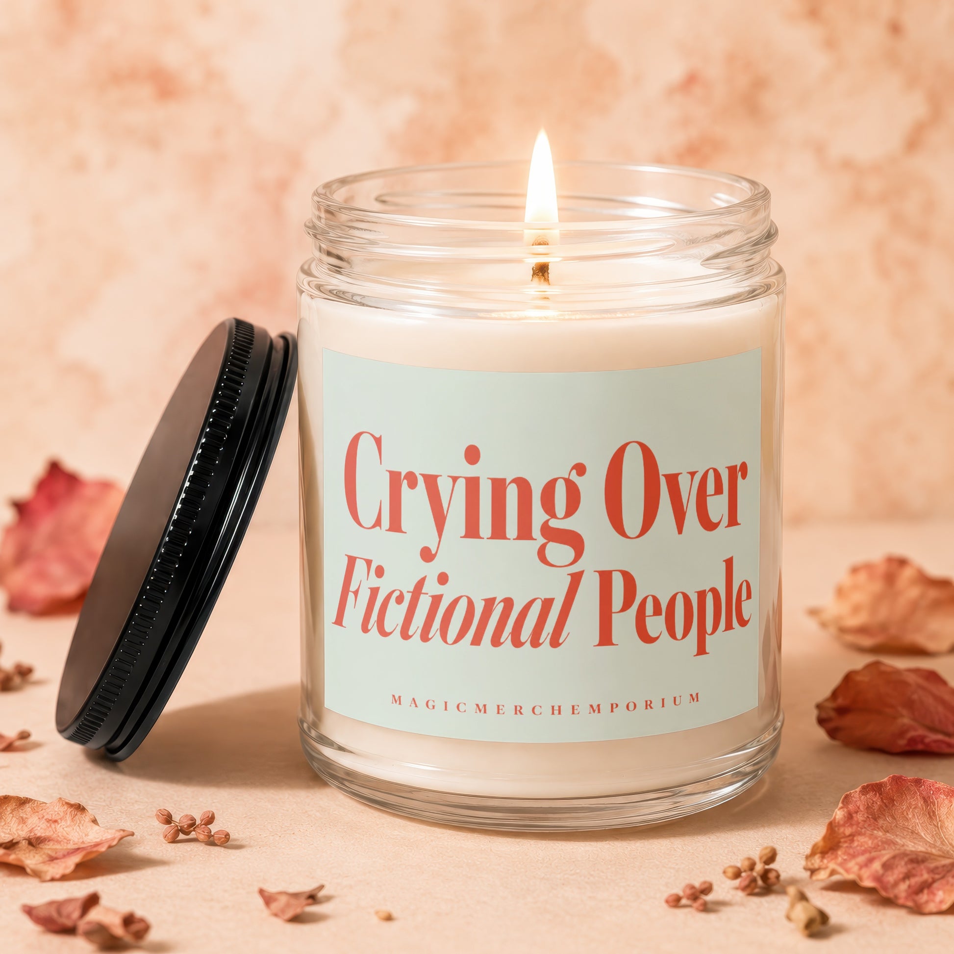Jar candle with lit wick and light blue label that says "Crying Over Fictional People".