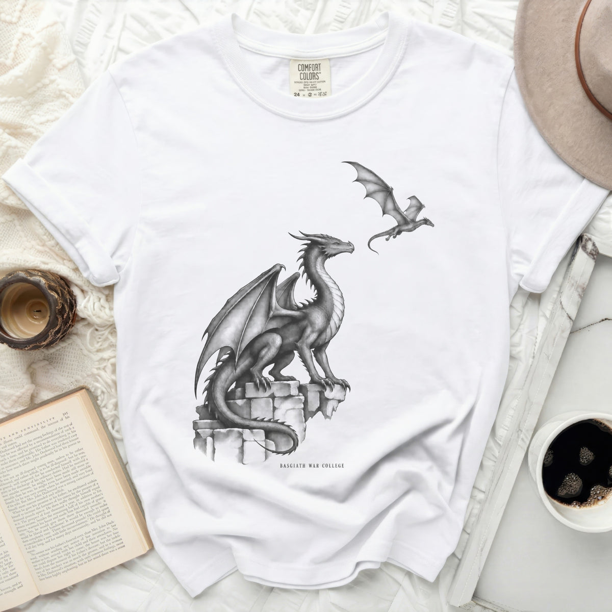 White t-shirt with a large dragon on stone and a smaller dragon flying, text reads "BASGIATH WAR COLLEGE".