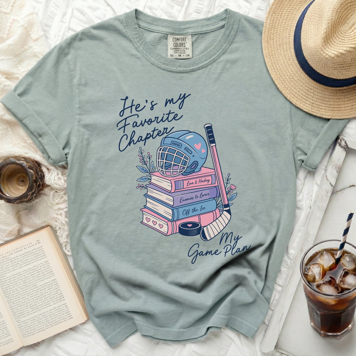 Light blue t-shirt with "He's my favorite chapter" and hockey themes.