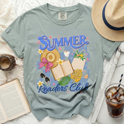 "Summer Readers Club" graphic on a sage green t-shirt with beach accessories and an open book.