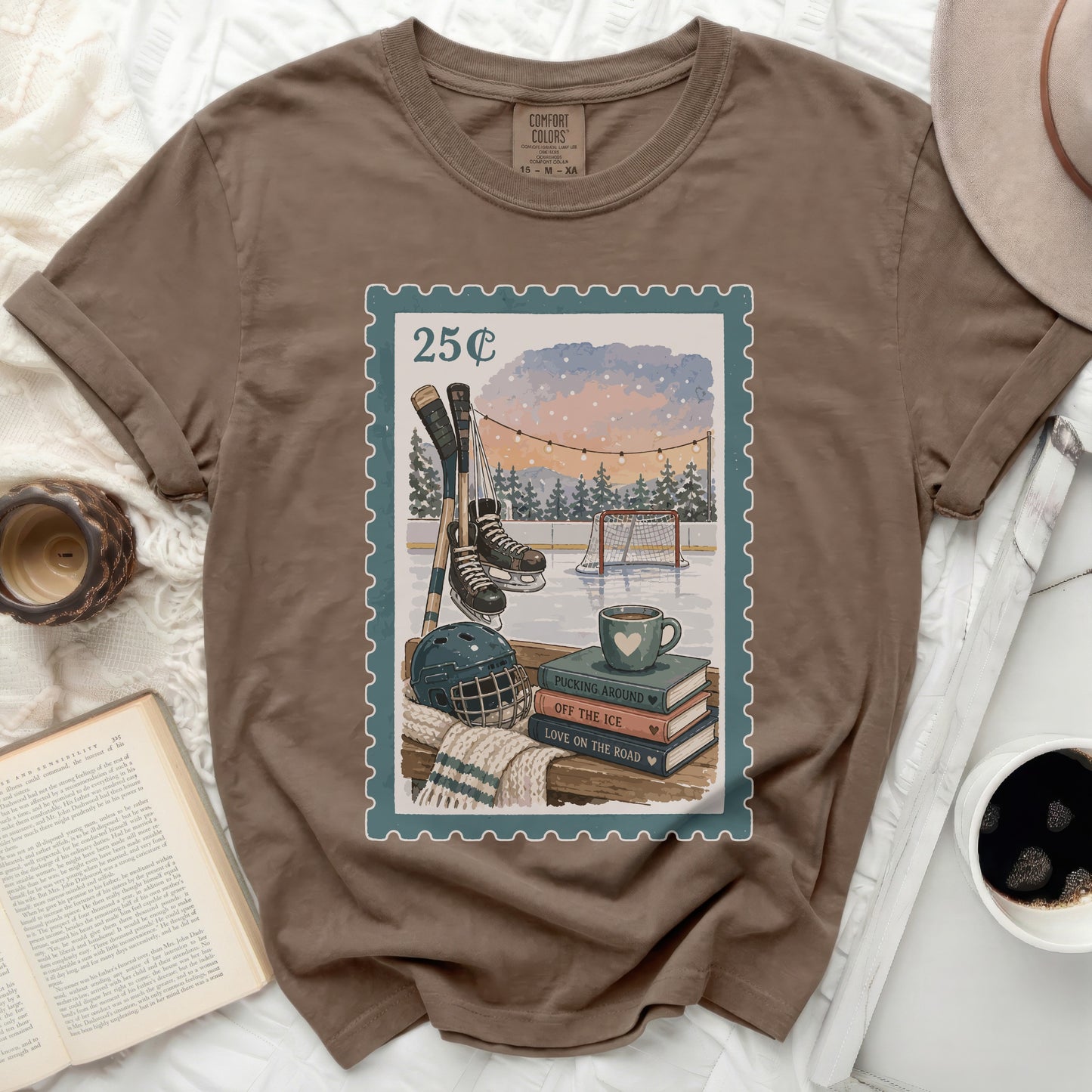 T-shirt with stamp design of hockey rink, skates, puck, and books.