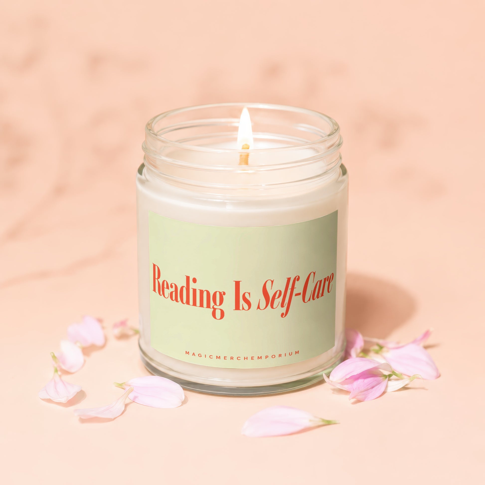 Lit candle in glass jar with "Reading Is Self-Care" on label and petals.