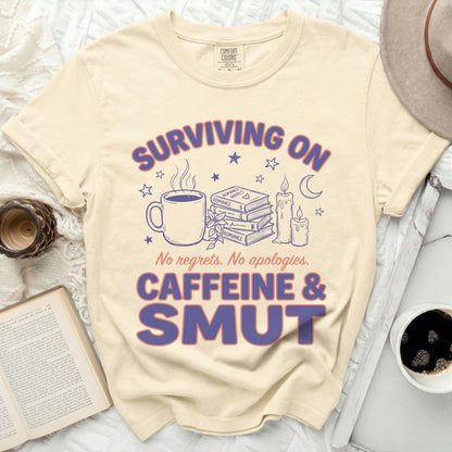 Surviving on caffeine and smut t-shirt with books, coffee, and candles.