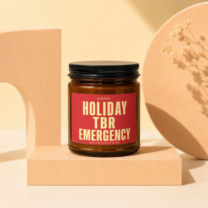 Brown candle labeled "Holiday TBR Emergency" on a display riser.