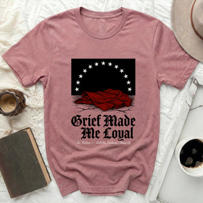Dark graphic on pink t-shirt with stars and "Grief Made Me Loyal" text.
