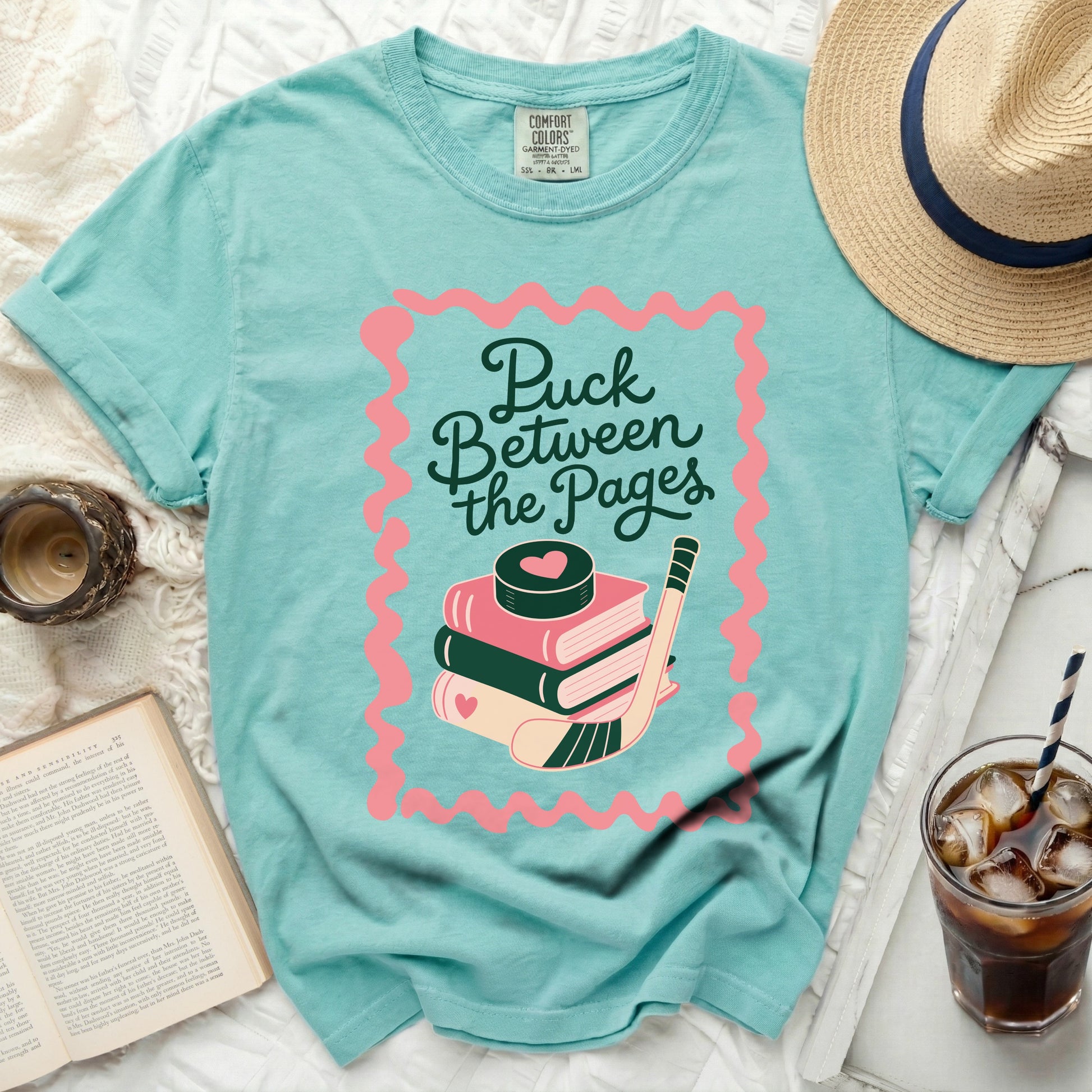 T-shirt with "Puck Between the Pages" and hockey equipment graphic.