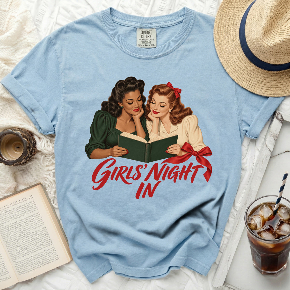 Light blue t-shirt with illustration of two women reading and text "Girls' Night In".