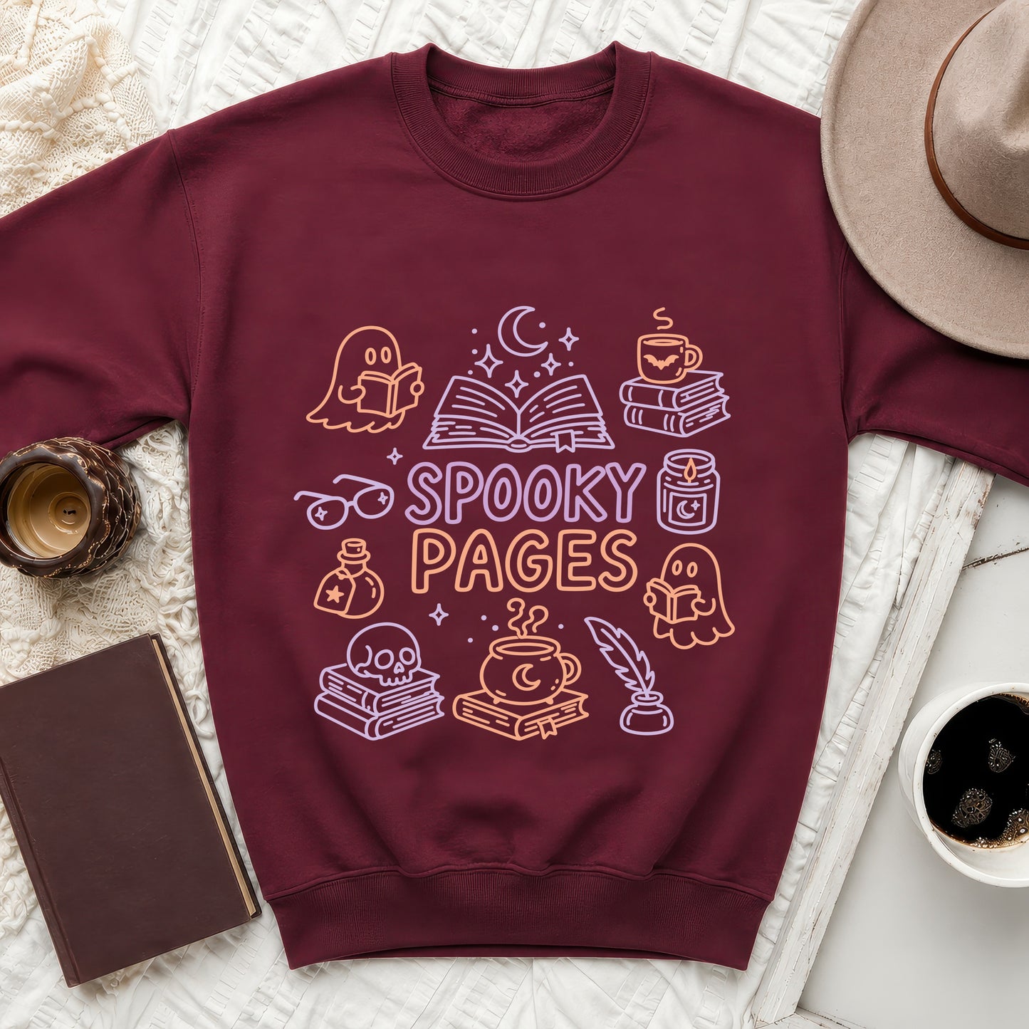 Maroon sweatshirt with whimsical ghost, book, and cauldron graphic reading "Spooky Pages".