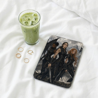 Three women in dark armor with swords stand before a mountain landscape on a tablet.