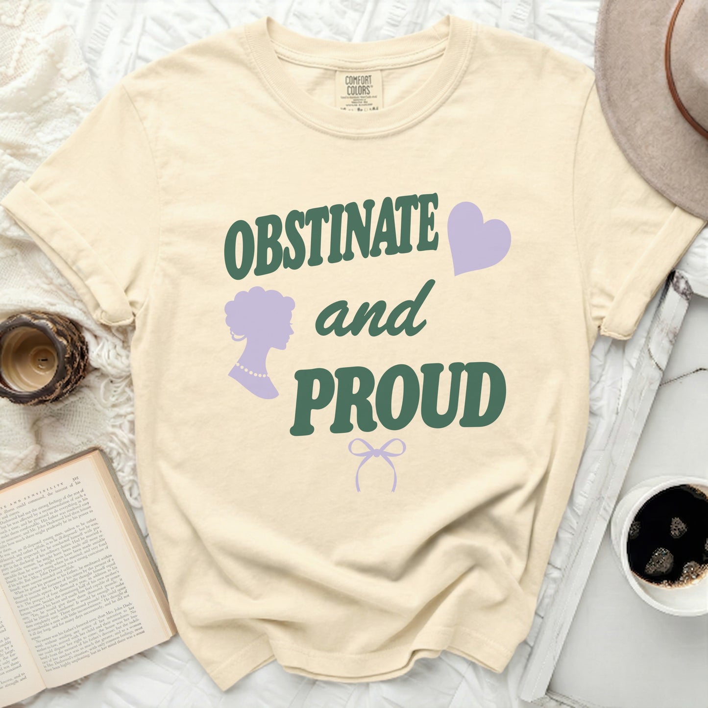 Cream t-shirt with "OBSTINATE and PROUD" in green text.