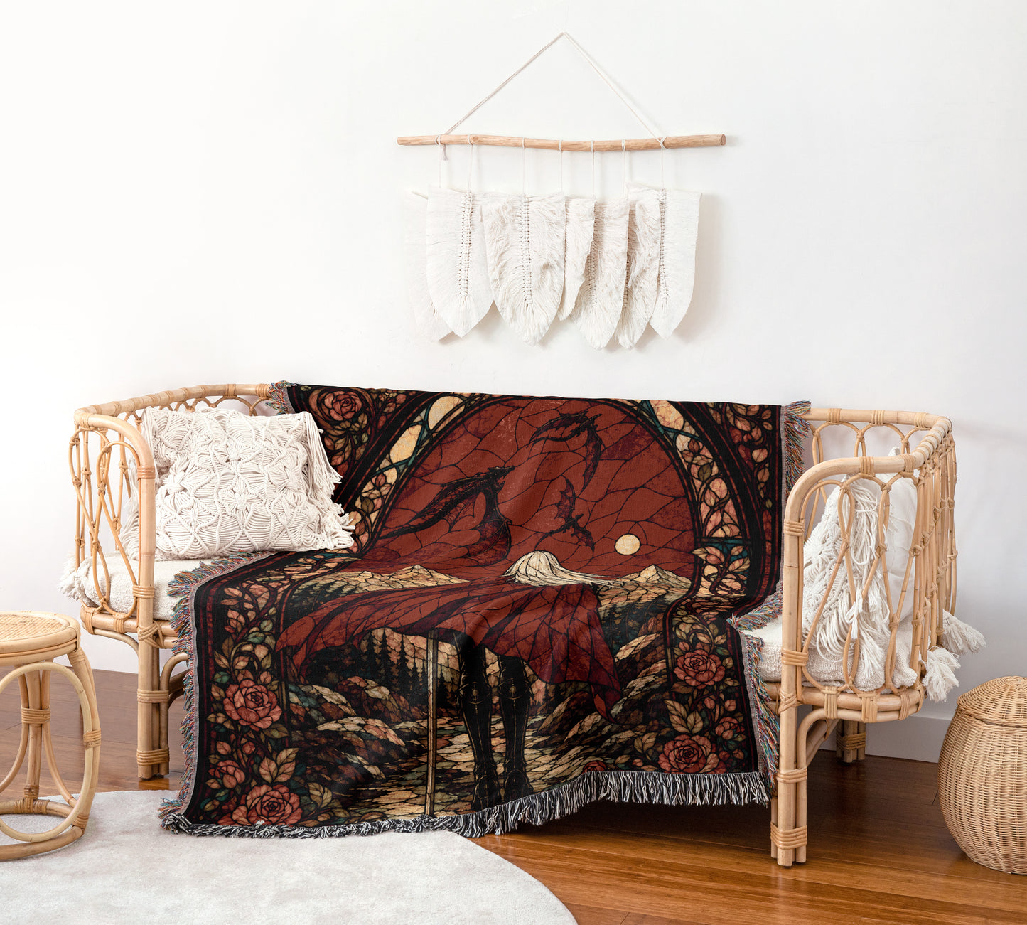 a cozy living space with a woven bench, a colorful throw blanket with a bird and mountain design, and a hanging wall decoration made of white feathers.