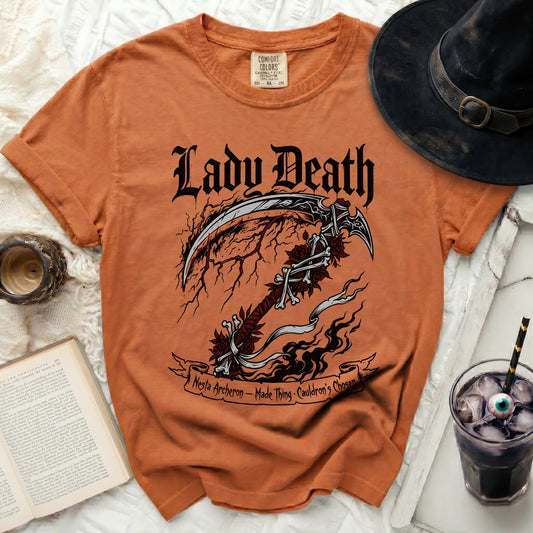 Orange t-shirt with "Lady Death" and scythe graphic, text reads "Nesta Archeron - Made Thing - Cauldron's Chosen".