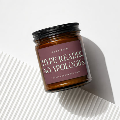 Amber glass candle with a dark label reading "CERTIFIED HYPE READER. NO APOLOGIES."