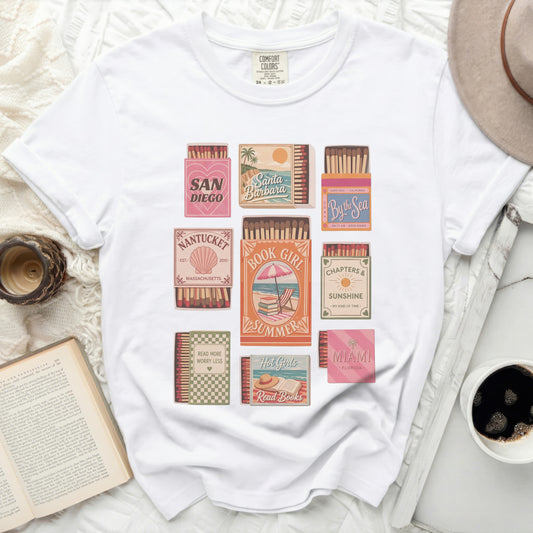 White t-shirt with retro vacation destination graphics and book quotes.