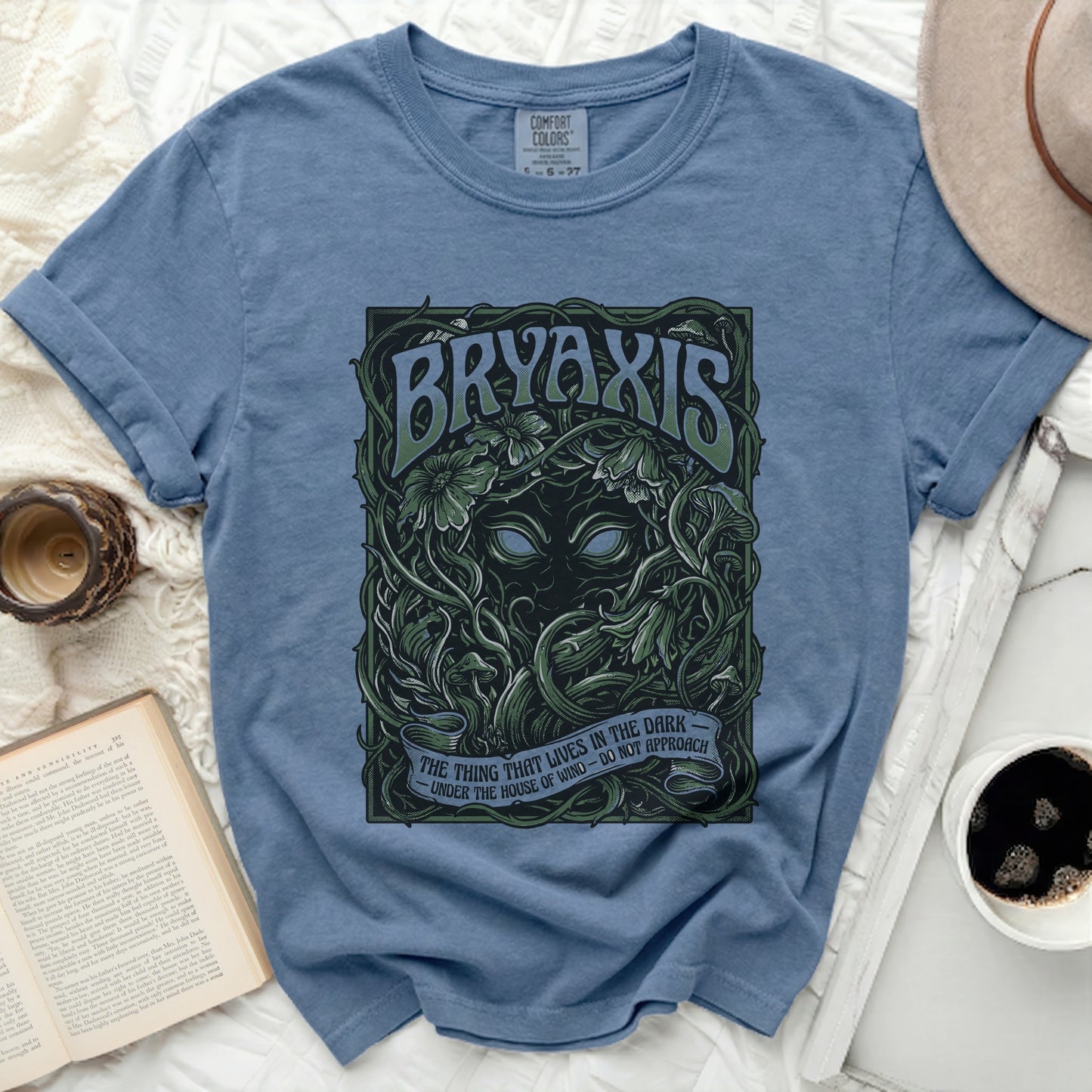 Blue t-shirt with "BRYAXIS" and "The Thing That Lives in the Dark" text.