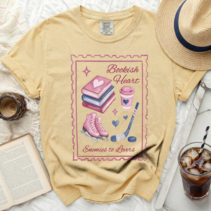 Yellow t-shirt with "Bookish Heart" text and graphic of books, skates, and hockey stick.