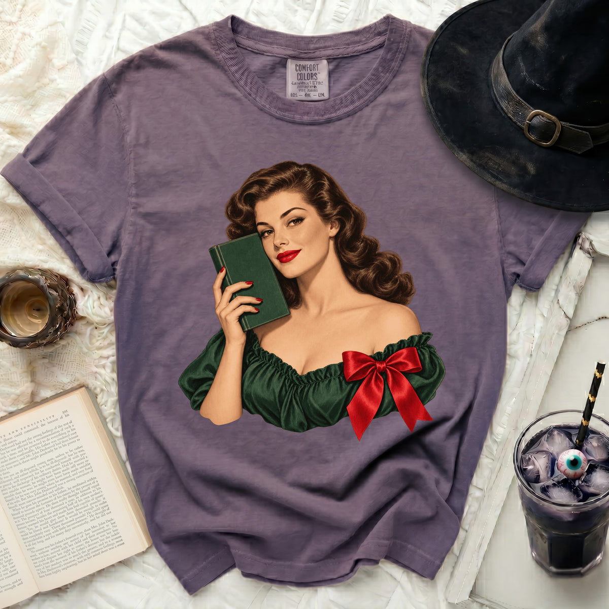 Purple t-shirt with vintage illustration of woman holding book and red bow.