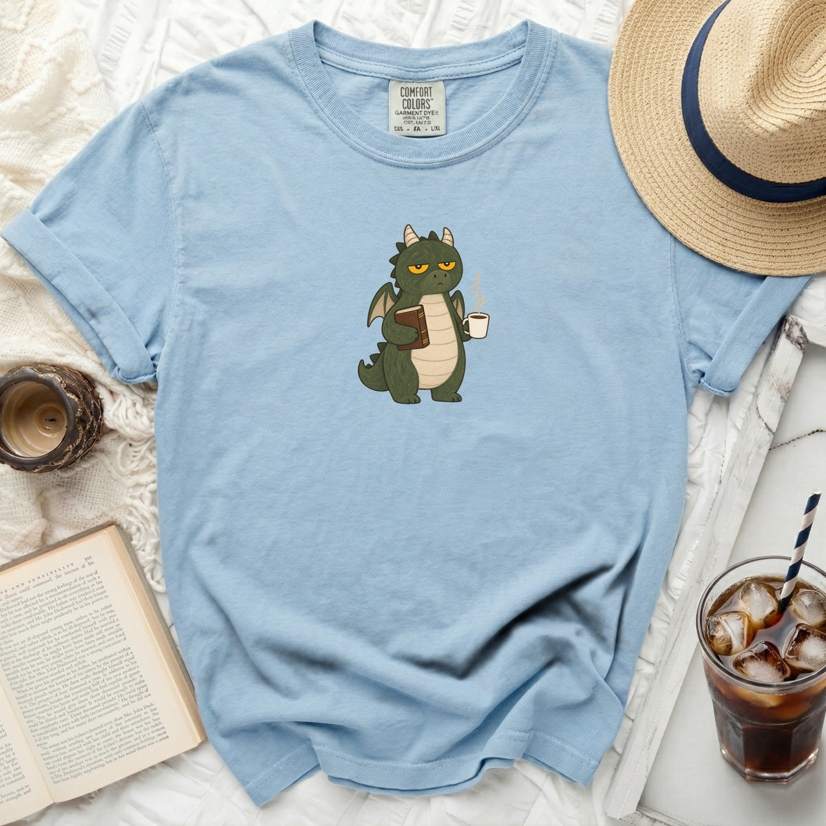Light blue t-shirt with a cartoon green dragon holding a book and coffee.