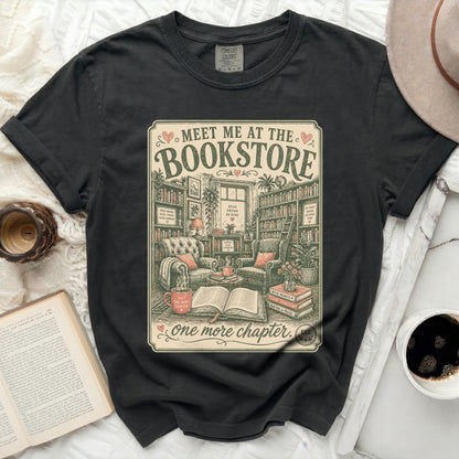 Dark t-shirt with "Meet Me at the Bookstore" graphic and cozy reading scene.