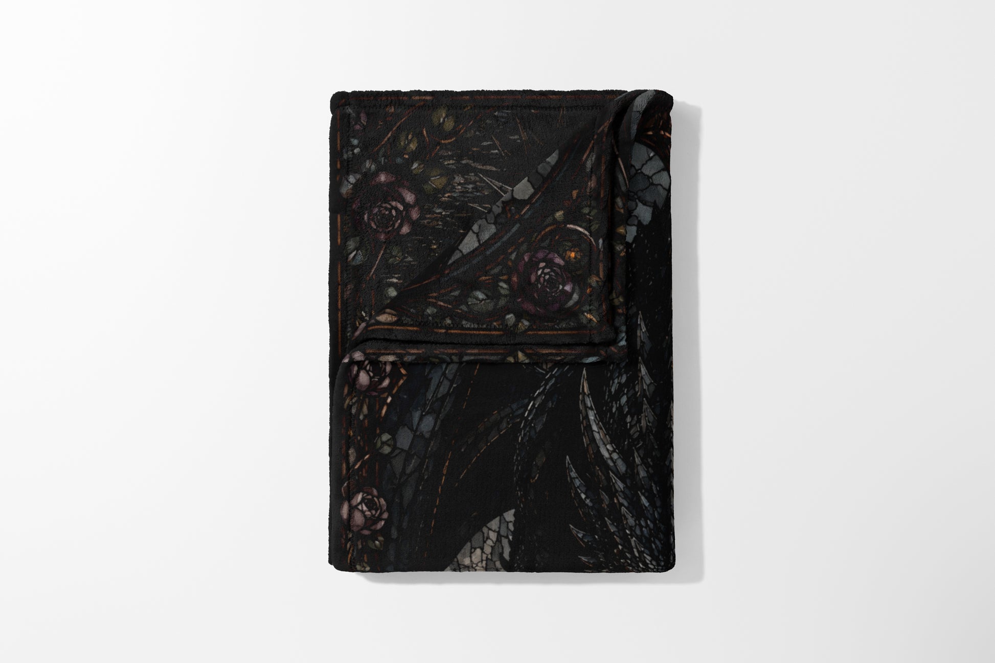 Black blanket with dark floral pattern and winged creature design.