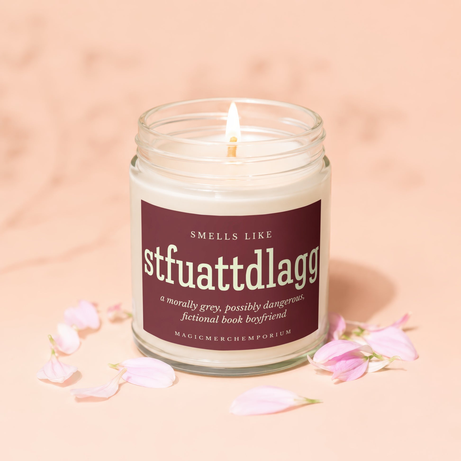 Lit candle in glass jar with label: "Smells Like stfuattdlagg, a morally grey, possibly dangerous, fictional book boyfriend."